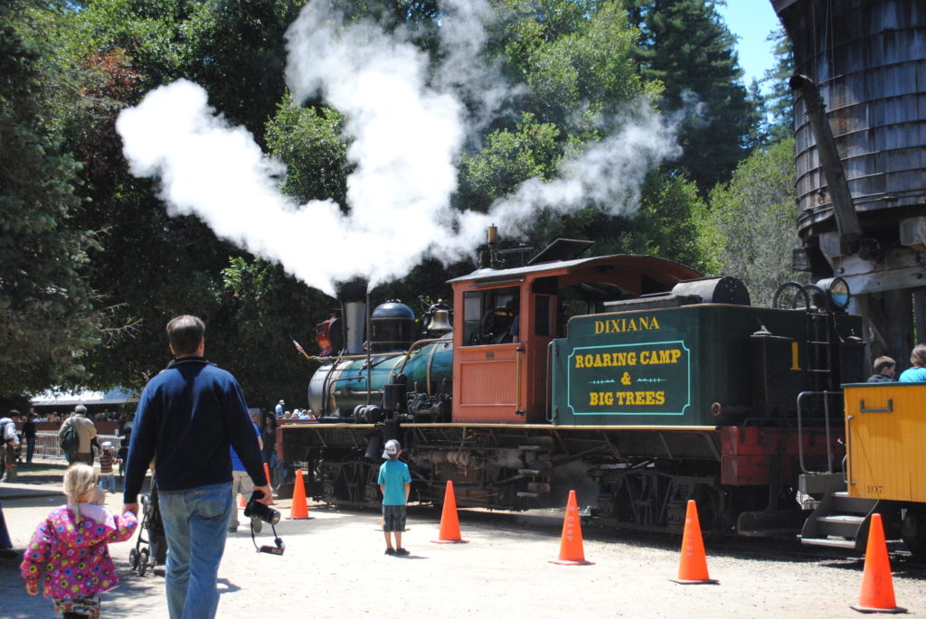 a steam engine blowing out steam at Roaring Camp Railroad at Henry Cowell Redwoods State Park