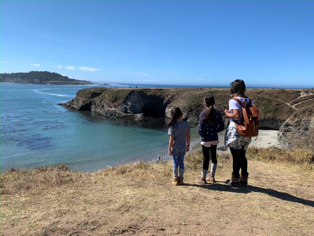 Three girls looking out at the Pacific Ocean in Mendocino, California