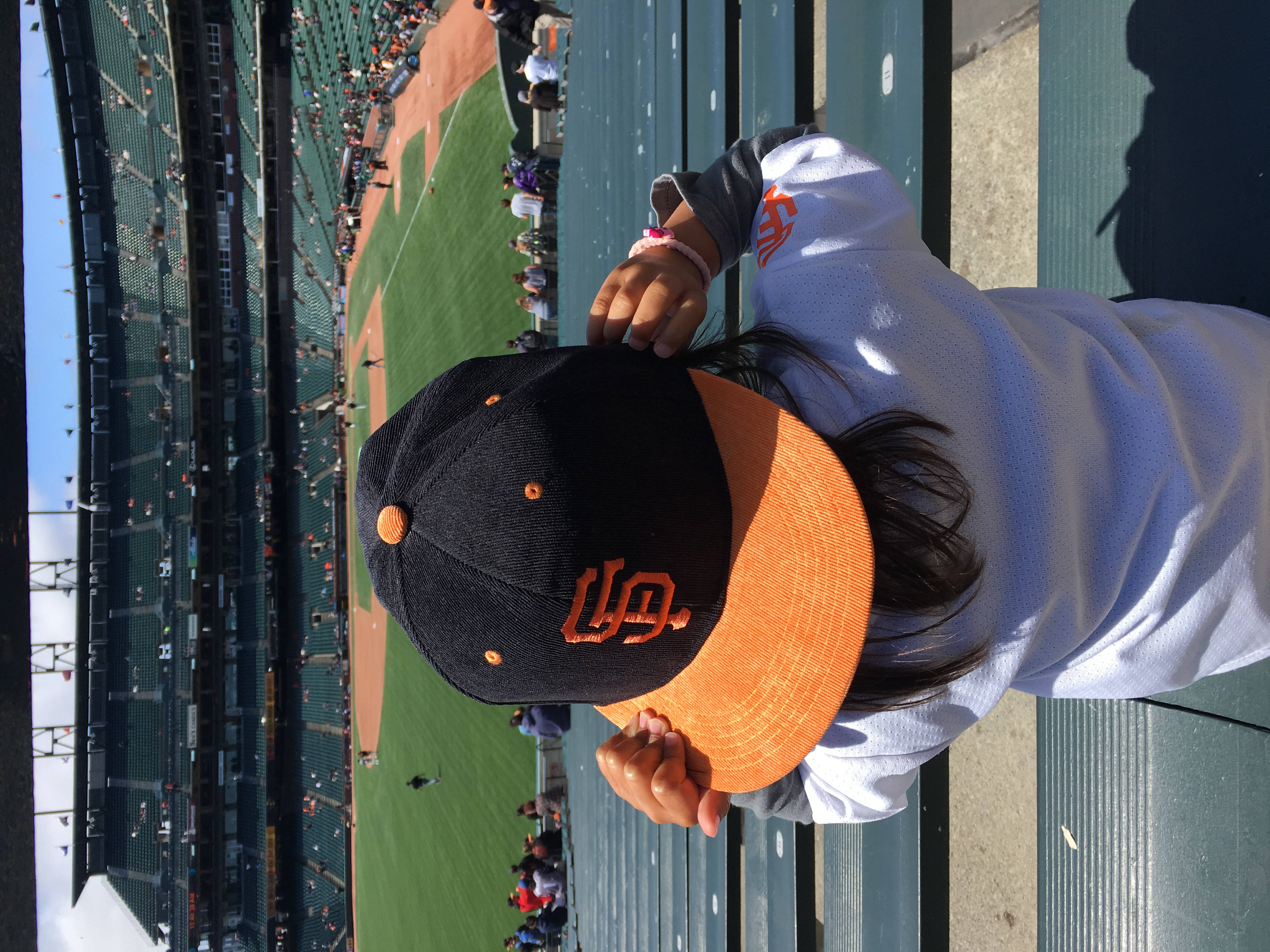 kid wearing at giants hat, watching a San francisco gaints game at oracle park