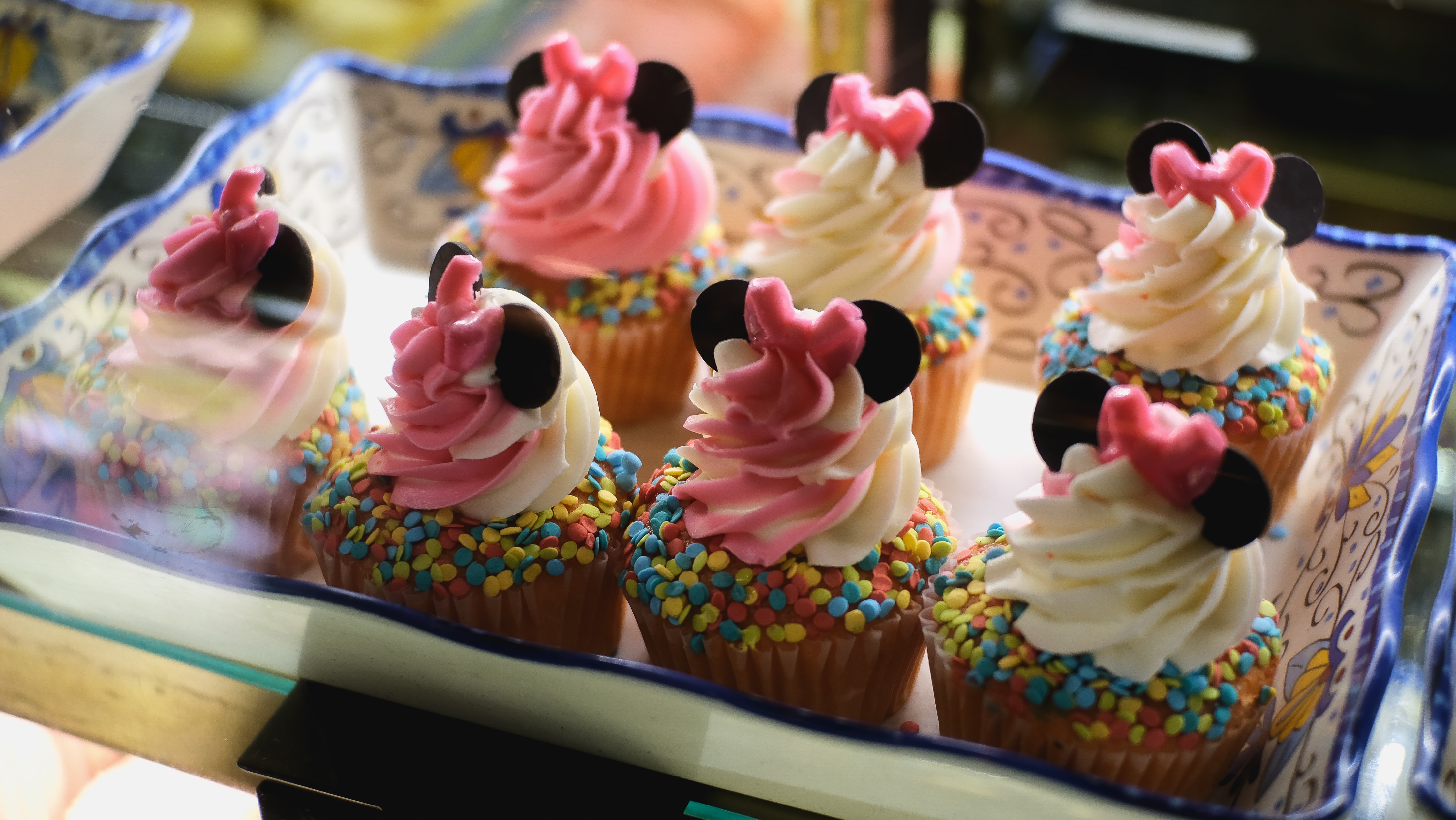 pink and white minnie mouse cupcakest with rainbow sprinkles and disneyworld