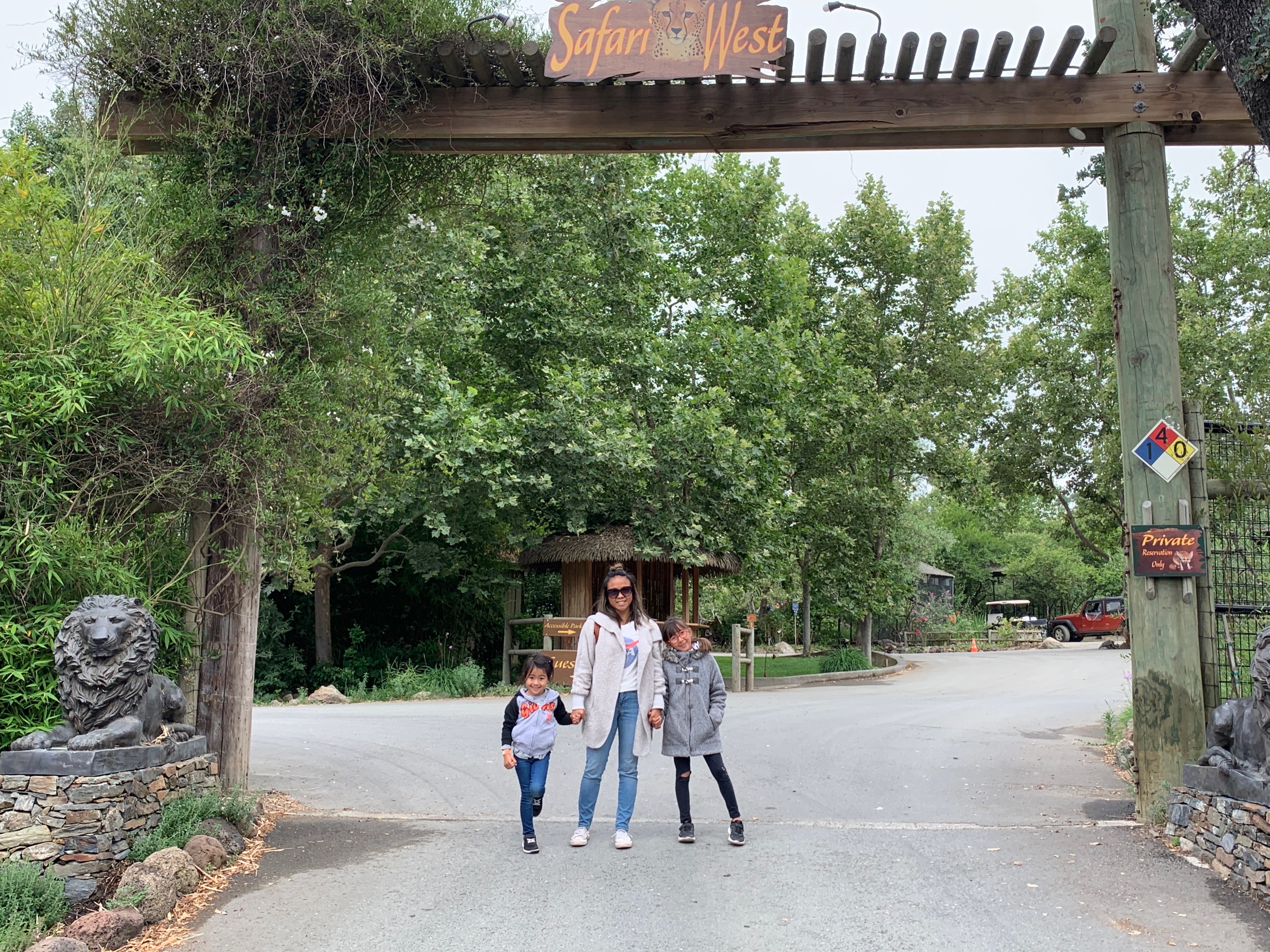 a mother and two daughters standing at the entry gates of Safari West in Santa Rosa, California