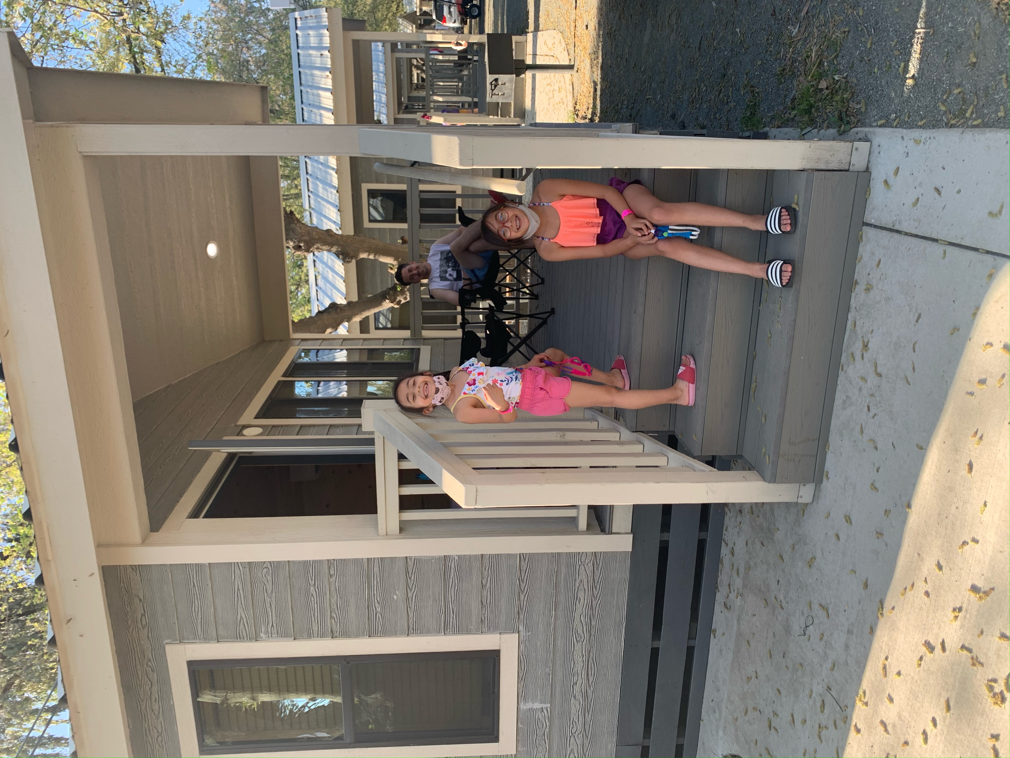 a family sitting on the porch of a cabin at yogi bear camp in Lodi, California