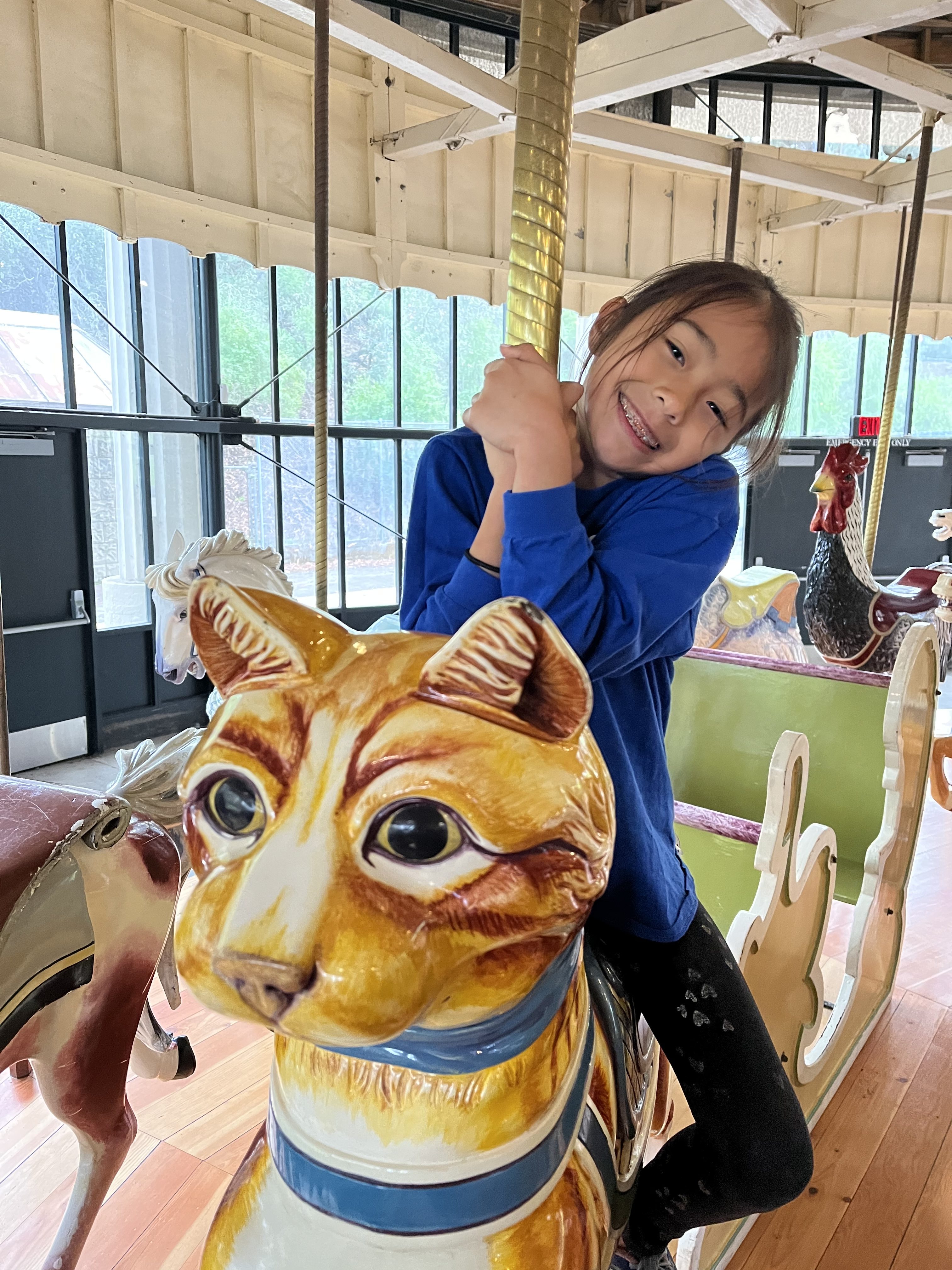 little girl riding the carousel at the koret children's quarter