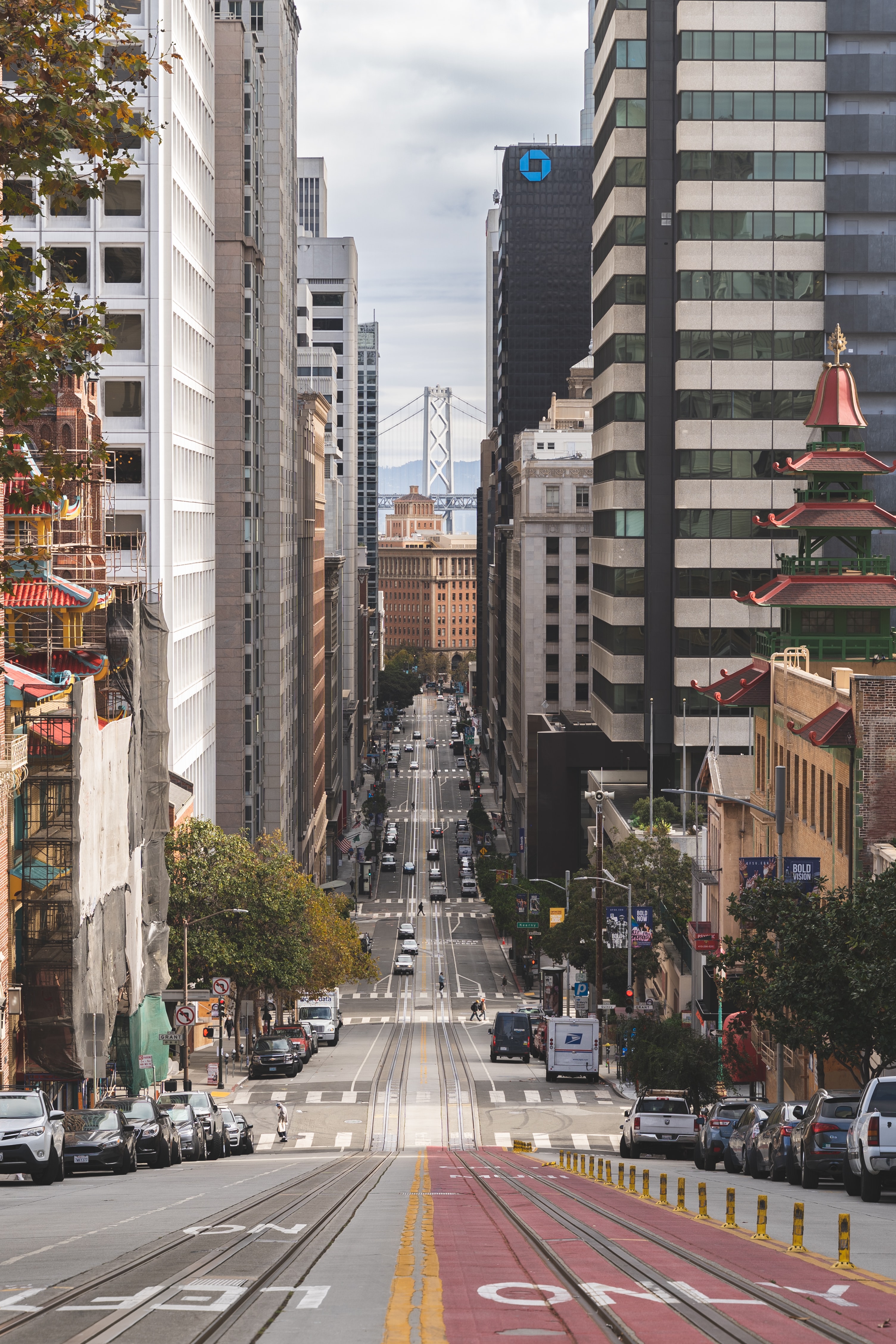 hilly san francisco street with the Bay Bridge in the Background