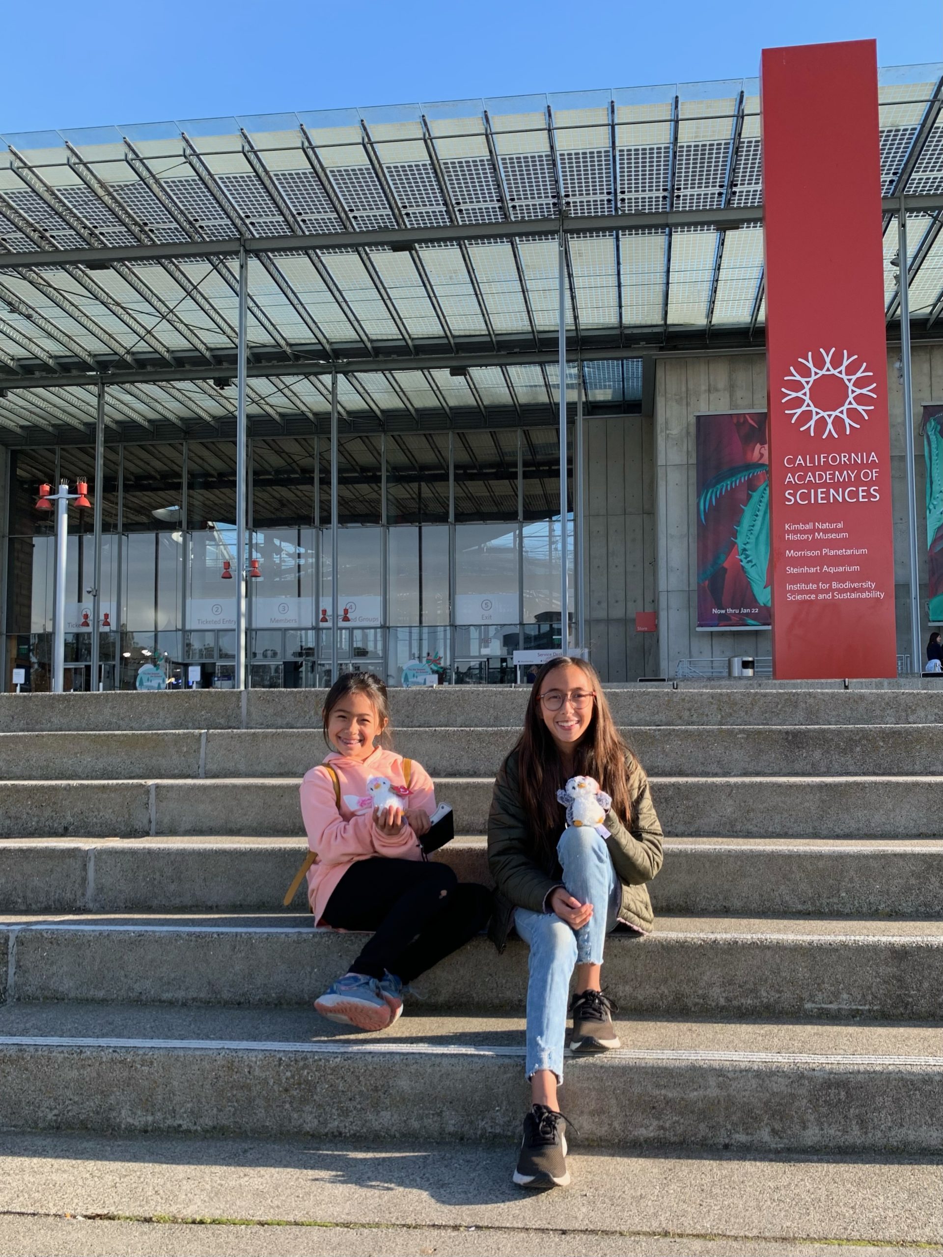 girls sitting in front of the California Academy of Sciences