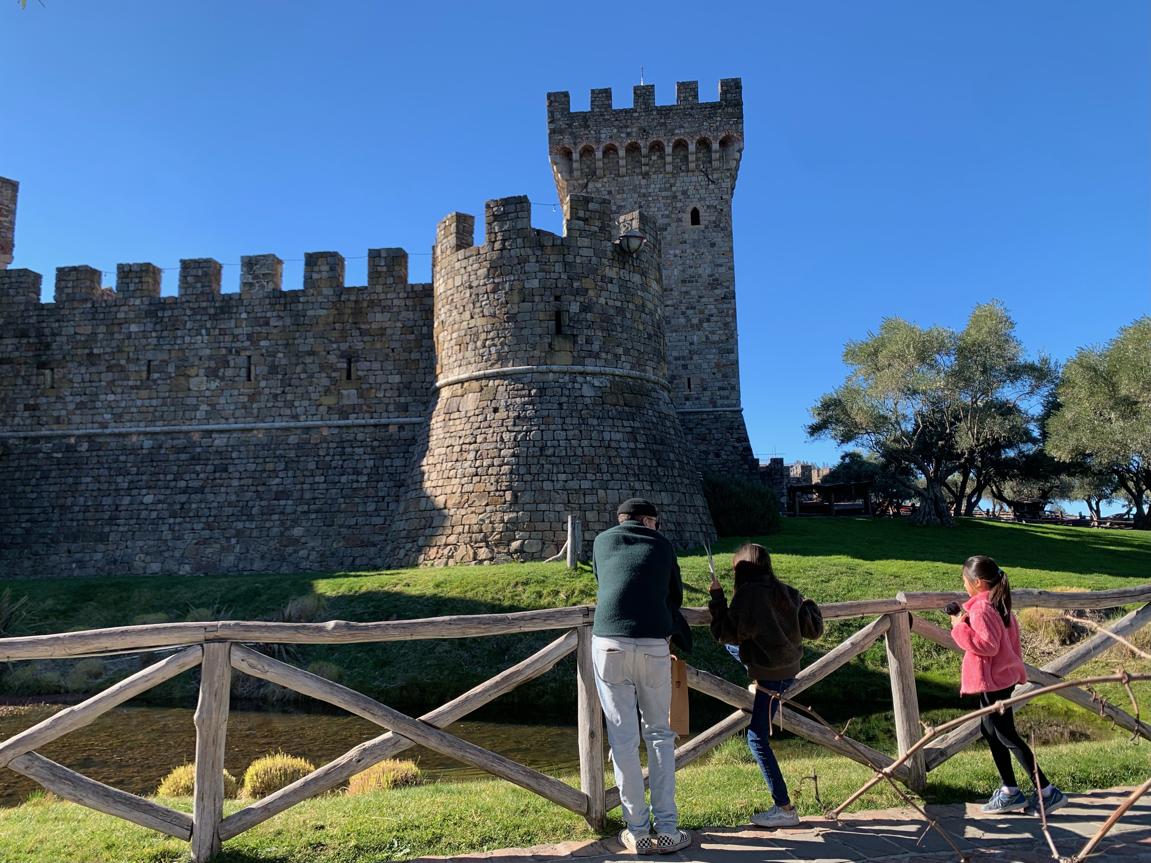 a family standing in front of castello di amorosa in calistoga, california