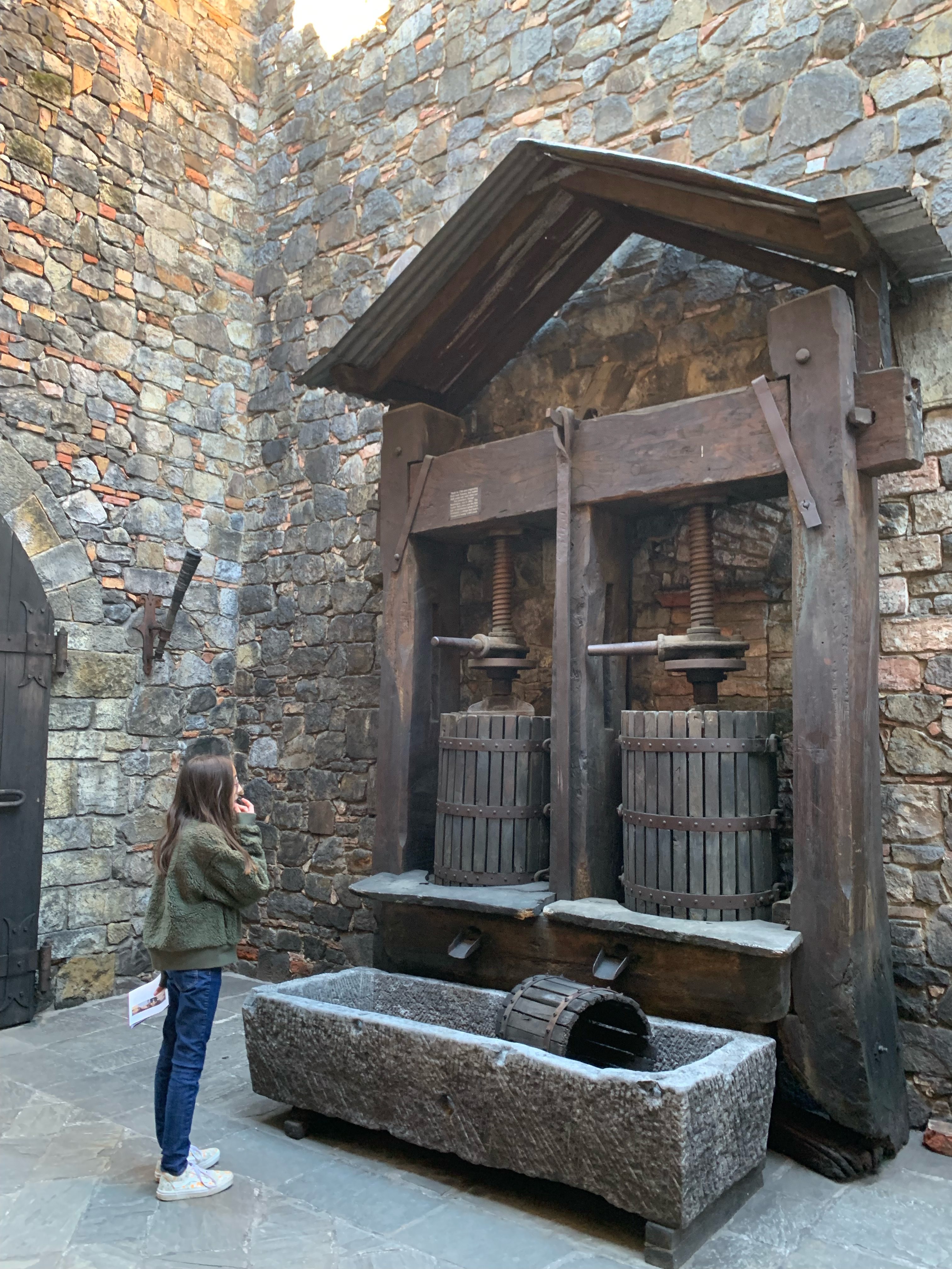 girl looking at a medeival contraption at Castello di Amorosa