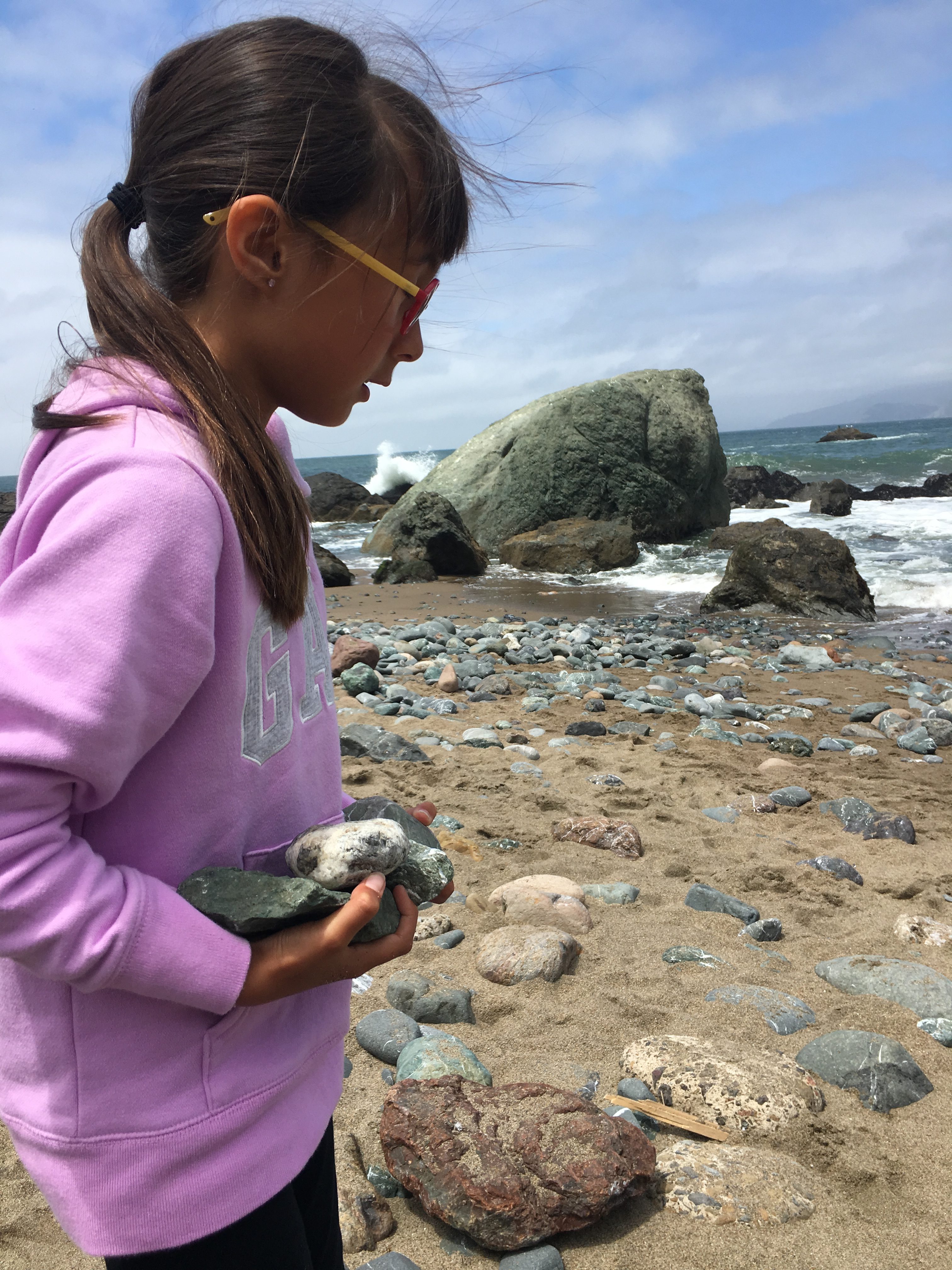 Girl holding a rock at Mile Rock Beach in San Francisco