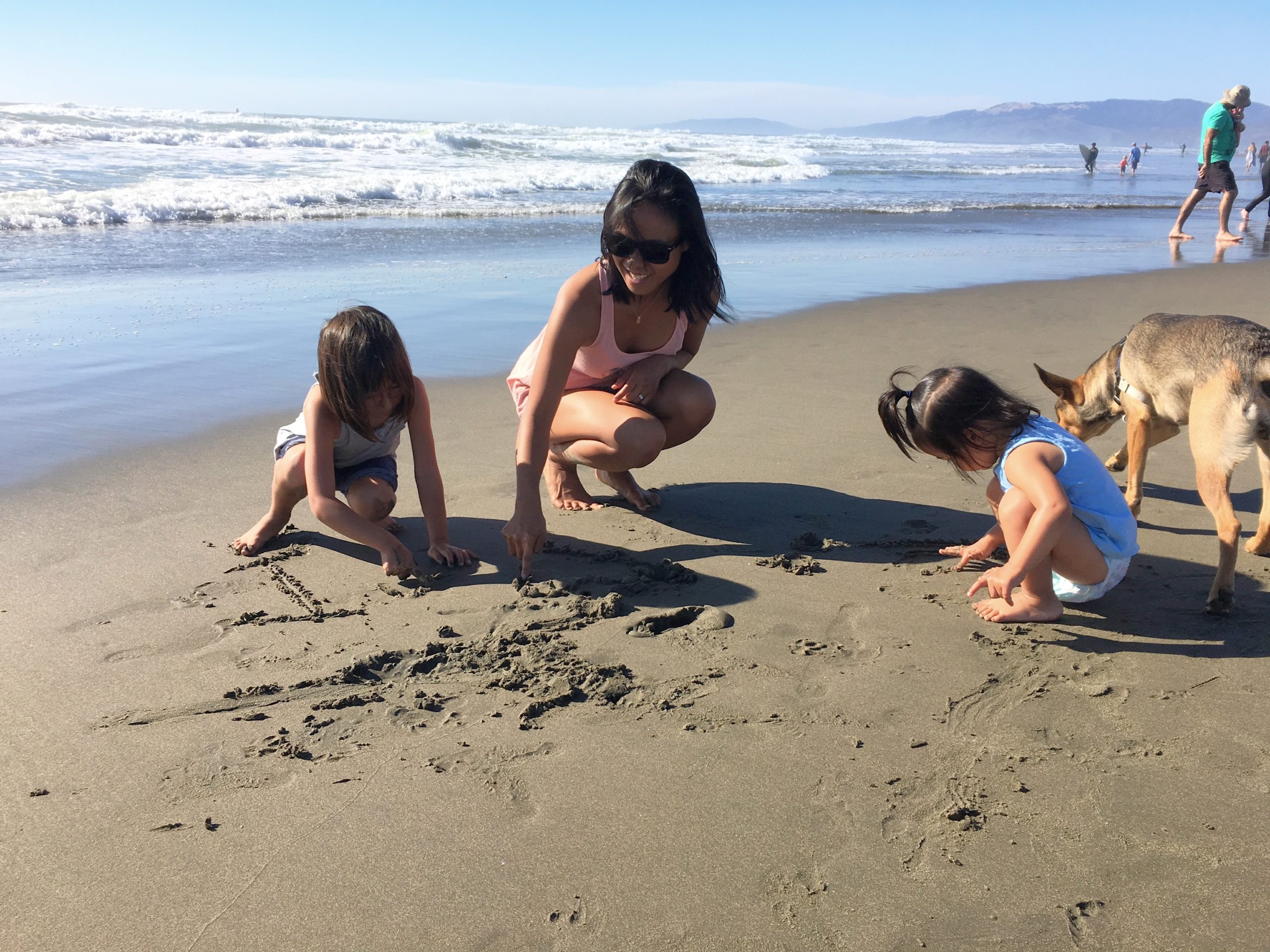 mom and daughters playing in the sand at Ocean Beach San Francisco