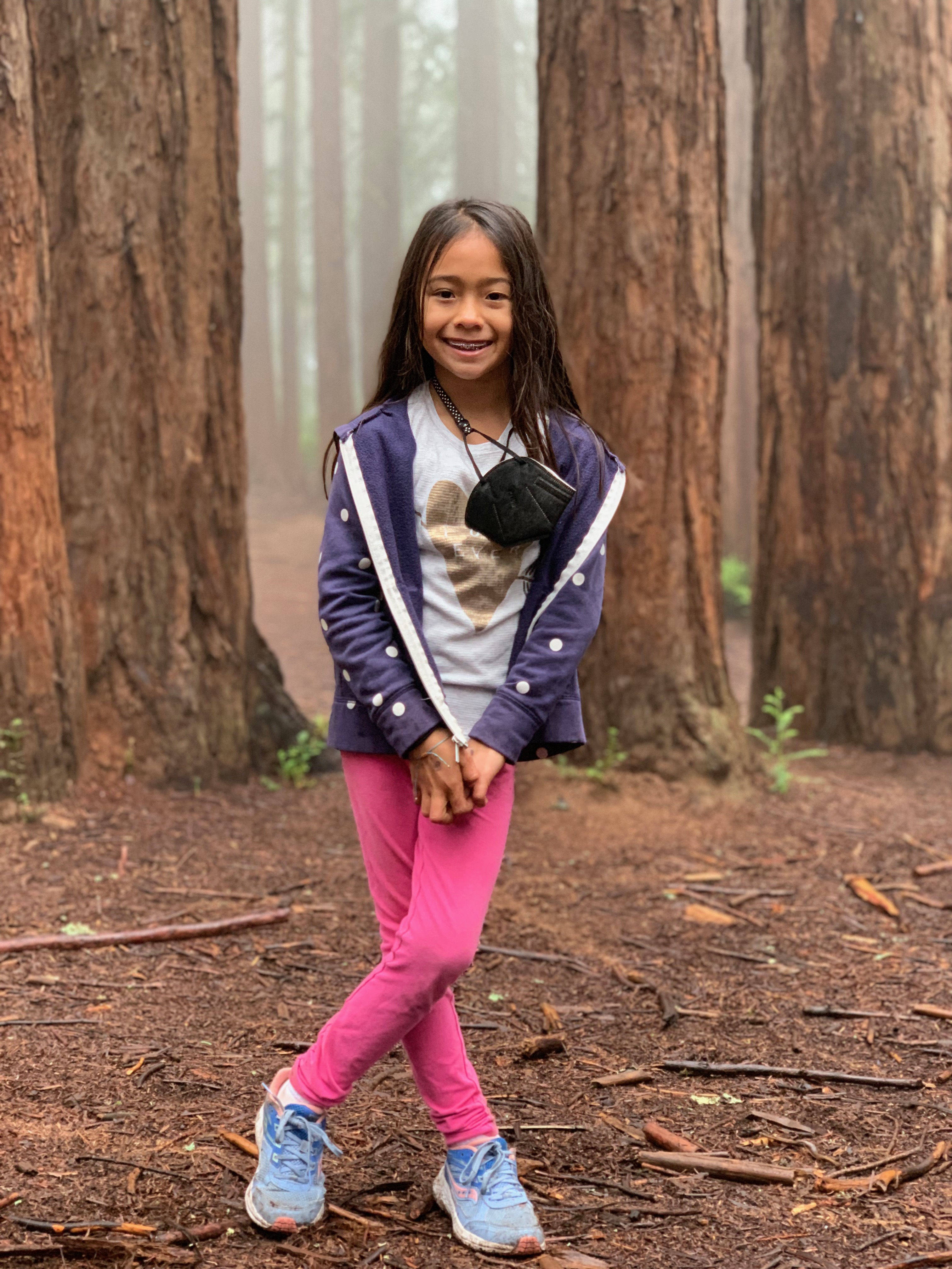 girl in the middle of a misty redwood forest