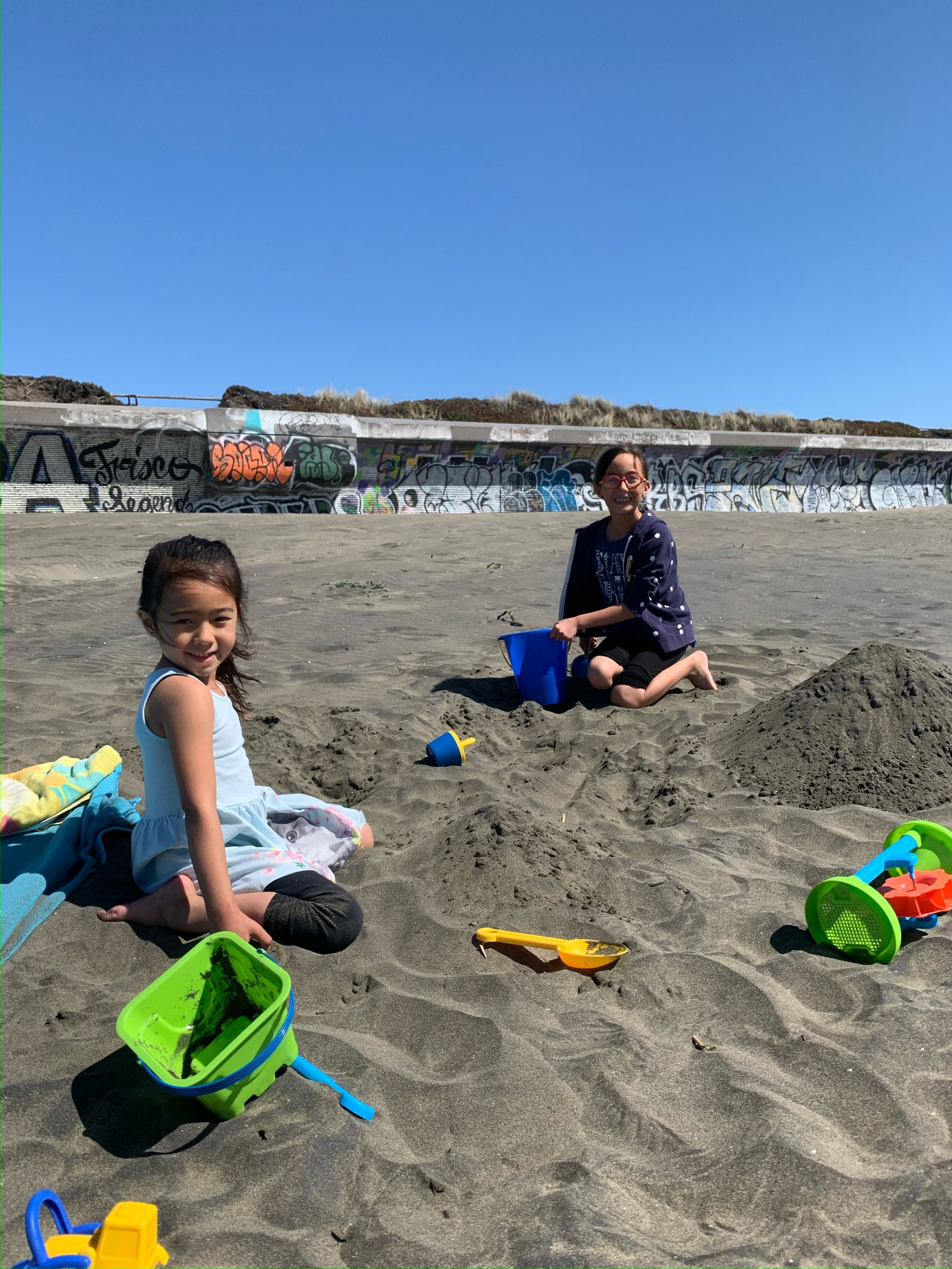 two girls playing in the sand at ocean beach san francisco