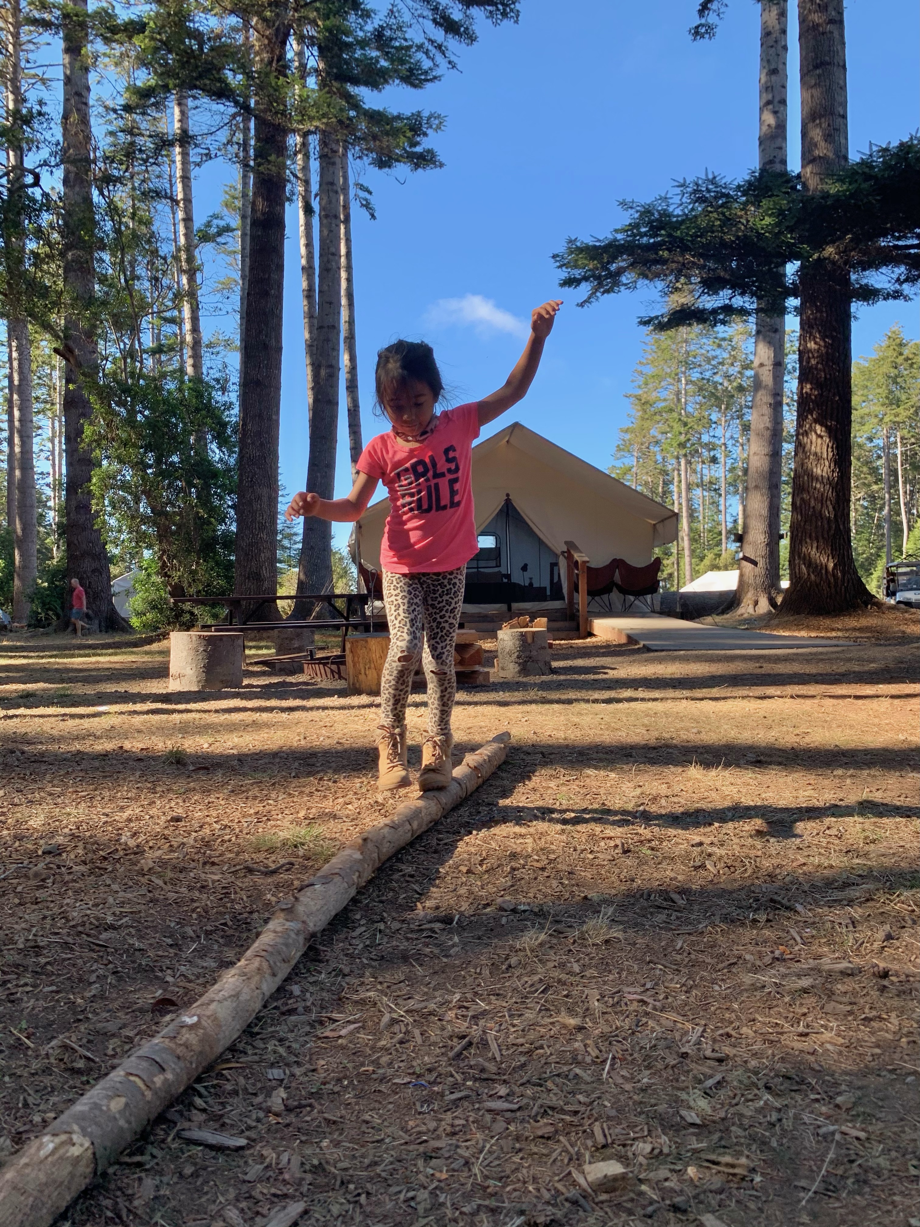 girl balancing on a log at mendocino grove california